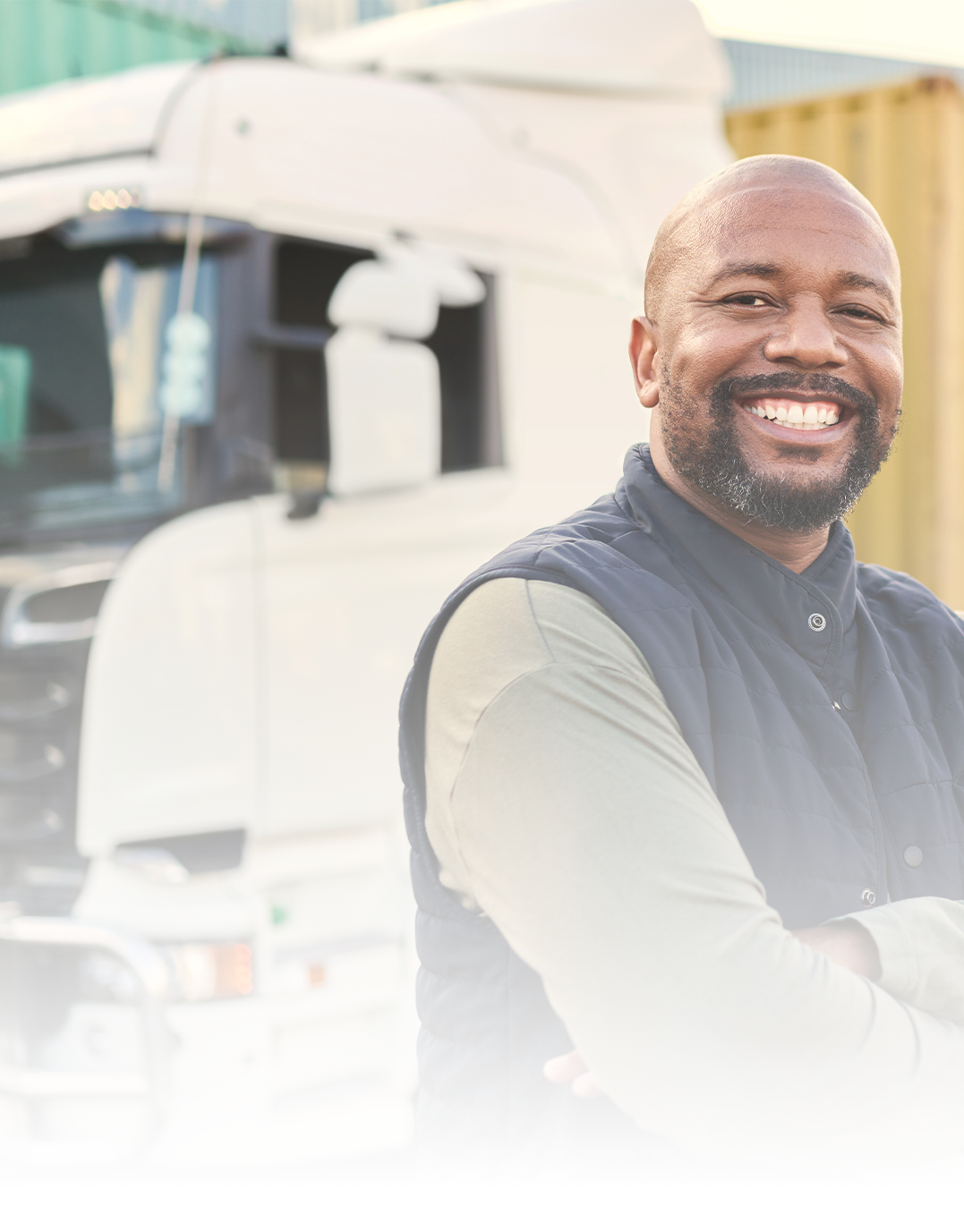 Smiling Bald Older Gentlemen Standing In Front Of A Large Freight Truck