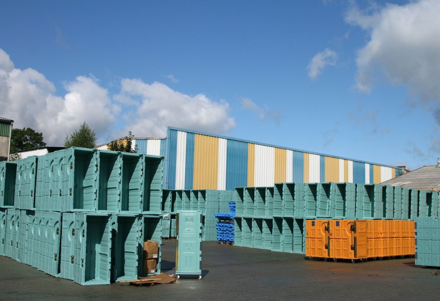 A field of open containers in front of a open blue sky with few grey clouds. Representing Collection Services in Logistics Warehousing and Distribution.